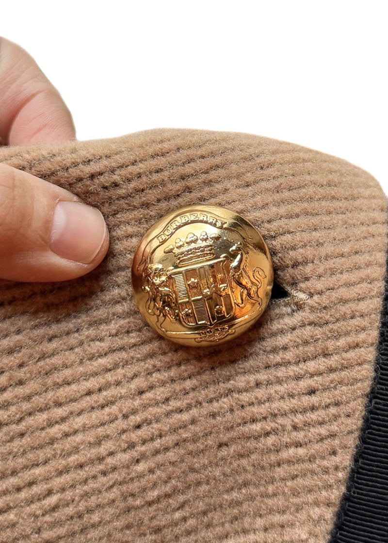 Close-up on branded button of Burberry Beige Wool Chain Accent Poncho Cape