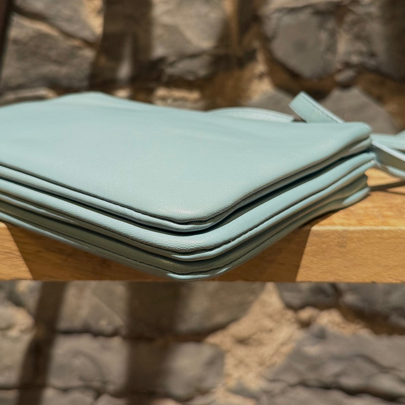 A bottom corner of Céline Light Blue Small Trio Crossbody Bag