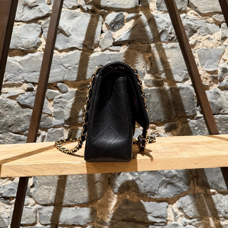 A side view of Chanel Black Caviar Jumbo GHW Classic Double Flap Bag