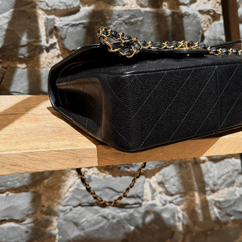 A bottom corner view of Chanel Black Caviar Jumbo GHW Classic Double Flap Bag