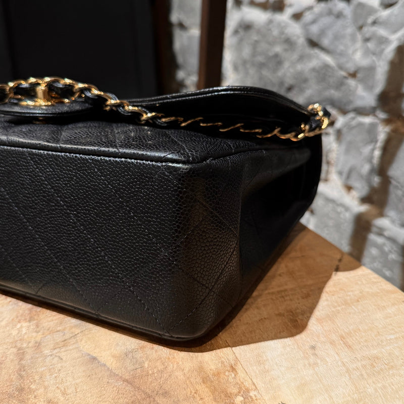 A bottom corner view of Chanel Black Caviar Jumbo GHW Classic Double Flap Bag