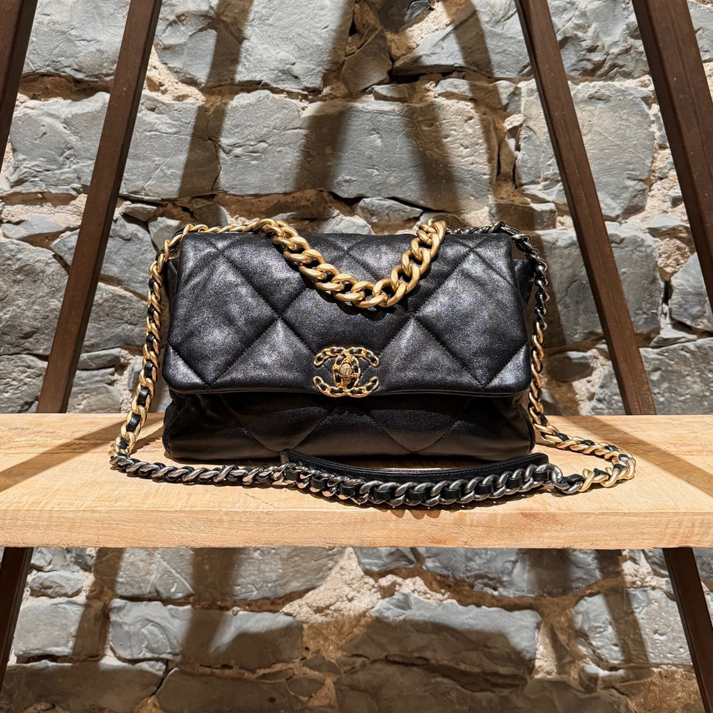 Chanel 2019 Large 19 Chain Flap Bag in black shiny calfskin leather with diamond quilted stitching. Features a mixed-metal chain strap with intertwined leather, a gold-tone CC logo turn-lock closure, and a back slip pocket with a snap button closure. The interior is lined in red fabric with a zip pocket and a gold-tone Chanel logo plaque.