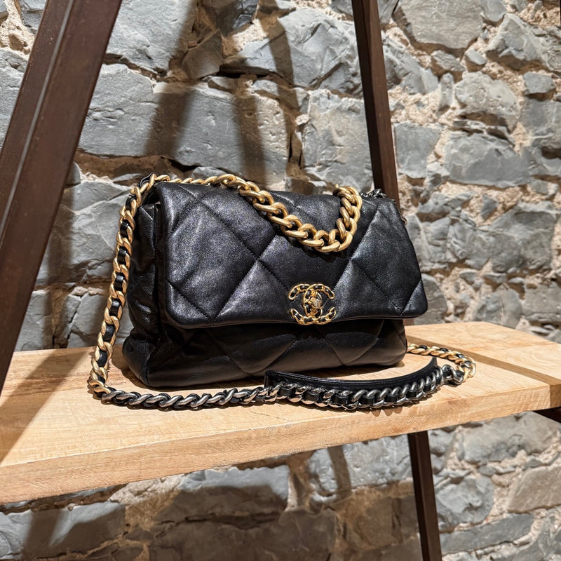 Chanel 2019 Large 19 Chain Flap Bag in black shiny calfskin leather with diamond quilted stitching. Features a mixed-metal chain strap with intertwined leather, a gold-tone CC logo turn-lock closure, and a back slip pocket with a snap button closure. The interior is lined in red fabric with a zip pocket and a gold-tone Chanel logo plaque.