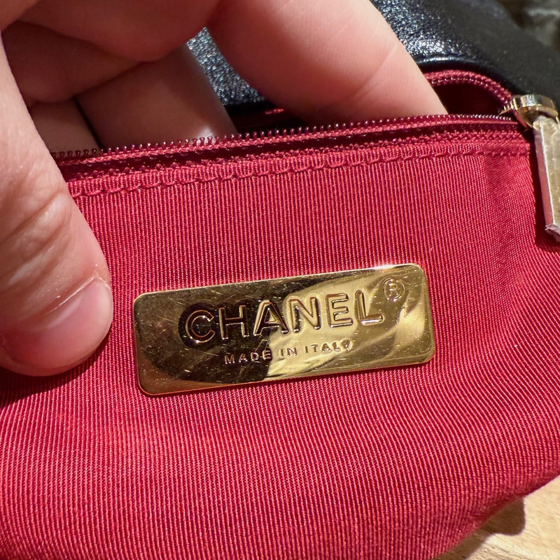 Chanel 2019 Large 19 Chain Flap Bag in black shiny calfskin leather with diamond quilted stitching. Features a mixed-metal chain strap with intertwined leather, a gold-tone CC logo turn-lock closure, and a back slip pocket with a snap button closure. The interior is lined in red fabric with a zip pocket and a gold-tone Chanel logo plaque.