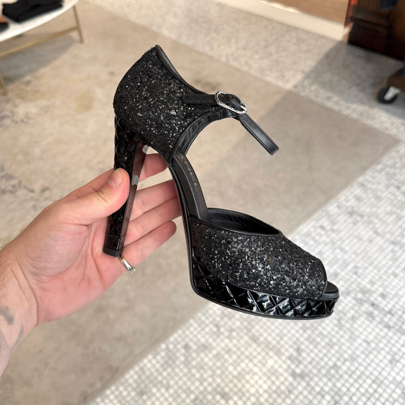 A side view of Chanel 2021 Black Glitter Platform Peep Toe Pumps
