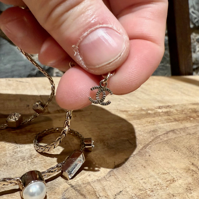 Close-up on CC logo of Chanel 22C Champagne Gold Crystals Pearls CC Chain Drop Necklace