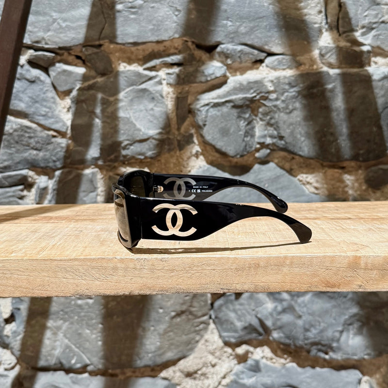 CC logo on branch of Chanel 5526 Black Acetate Clear CC Rectangular Sunglasses