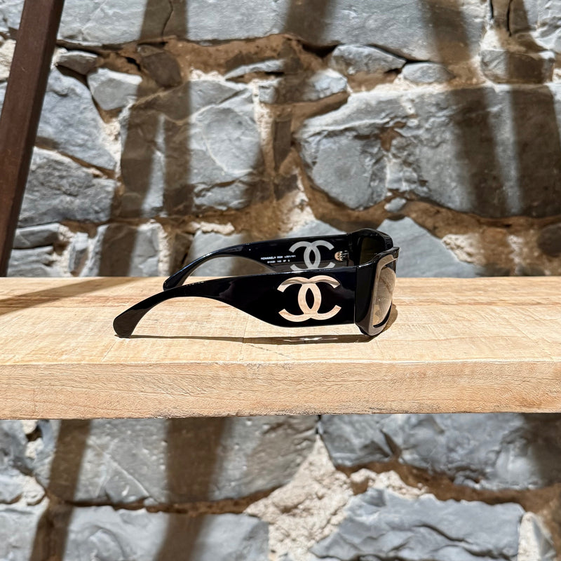 CC logo on branch of Chanel 5526 Black Acetate Clear CC Rectangular Sunglasses