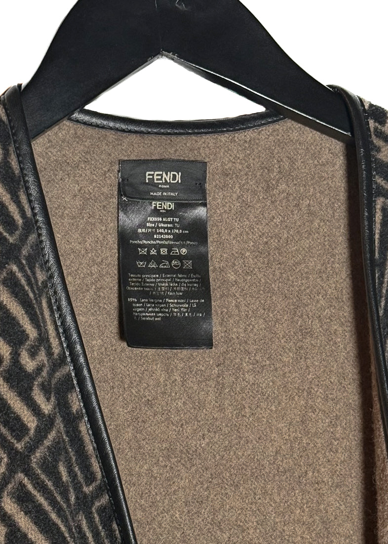 Fendi FF Monogram Leather Trim Wool Fringed Poncho displayed on a hanger. The poncho features an all-over FF monogram pattern in taupe and black, leather trim along the edges, and fringed hems. A silver-tone Fendi logo embellishment is visible at the back. Various images highlight the front, back, close-ups of the fabric, care label, and logo details.