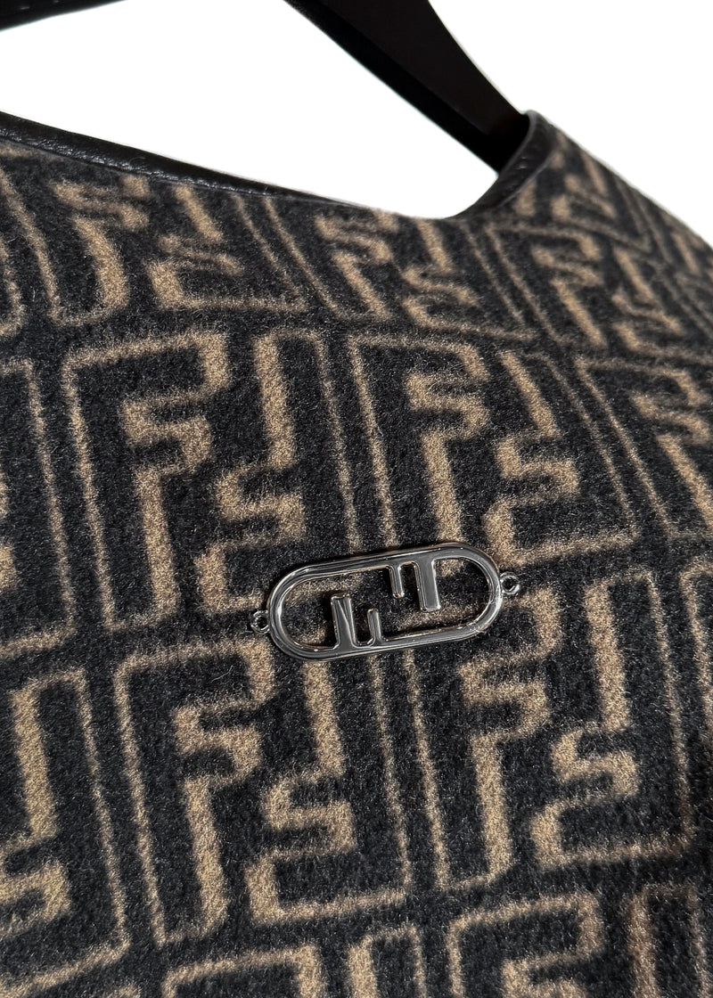 Fendi FF Monogram Leather Trim Wool Fringed Poncho displayed on a hanger. The poncho features an all-over FF monogram pattern in taupe and black, leather trim along the edges, and fringed hems. A silver-tone Fendi logo embellishment is visible at the back. Various images highlight the front, back, close-ups of the fabric, care label, and logo details.