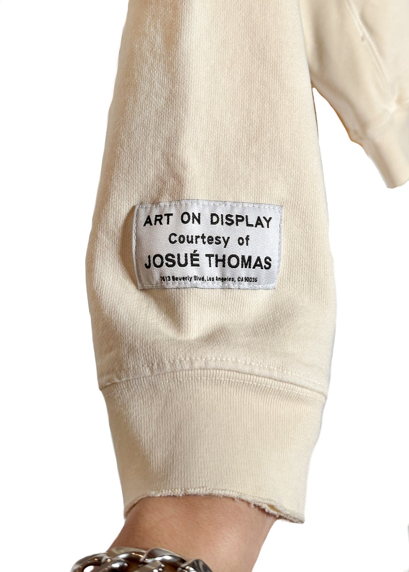 Close-up on one sleeve with a sewn-on patch reading "ART ON DISPLAY" of Gallery Dept. Ivory Gym Hoodie