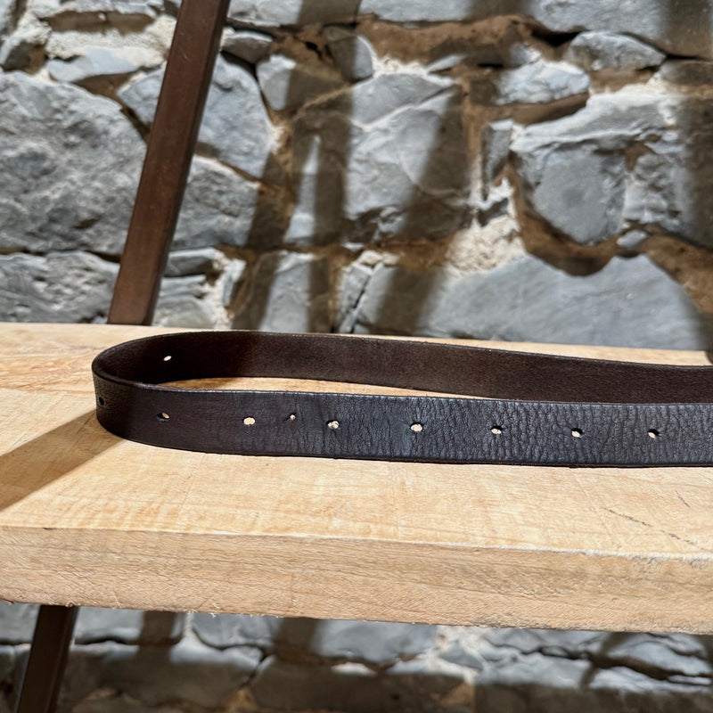 Gucci brown leather belt with silver-tone buckle, embossed branding, and adjustable strap, displayed on a wooden shelf.