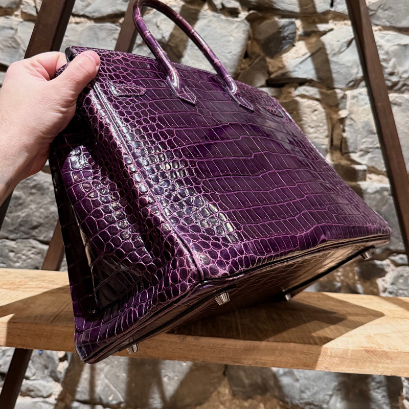 Side angle of Hermès 2014 Amethyst Shiny Porosus Crocodile Birkin 35 Bag highlighting its rolled leather handles