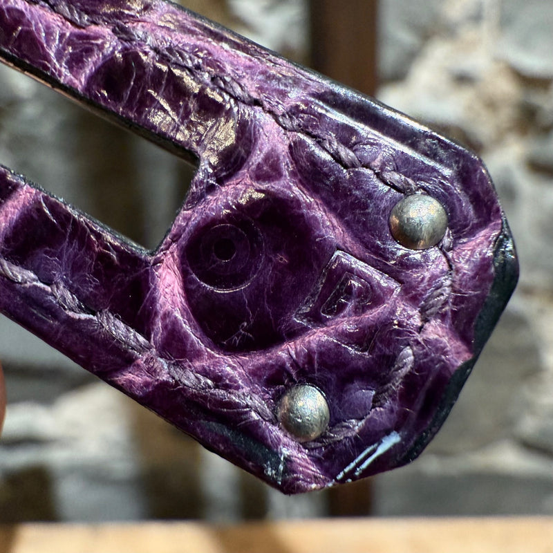 Detailed close-up of shiny porosus crocodile leather texture in amethyst hue on Hermès Birkin bag