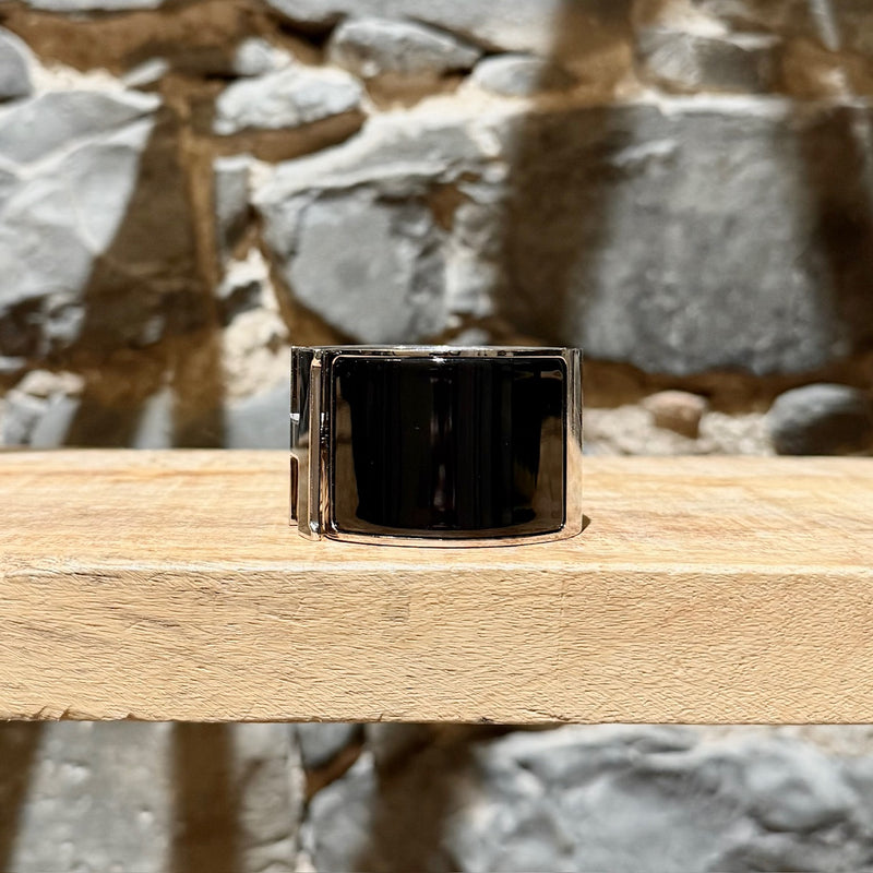 A side view of Hermès Black Enamel Extra Wide Clic Clac H PHW Bracelet