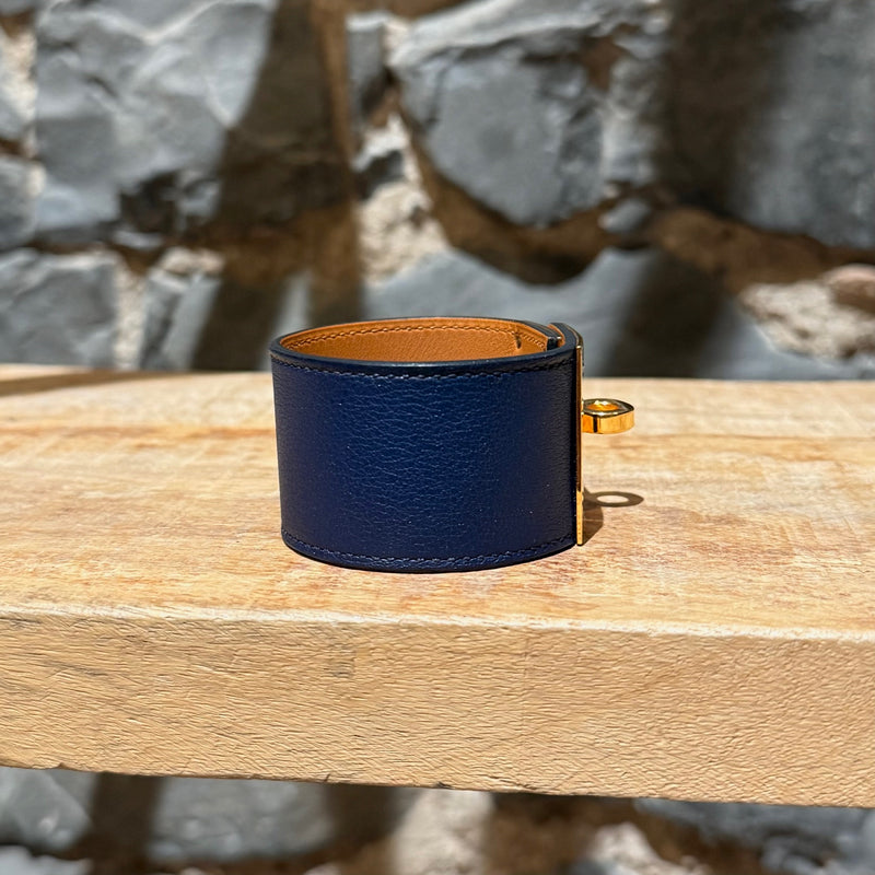 A side view of Hermès Blue Saphir Swift Leather Gold Plated Kelly Dog Bracelet