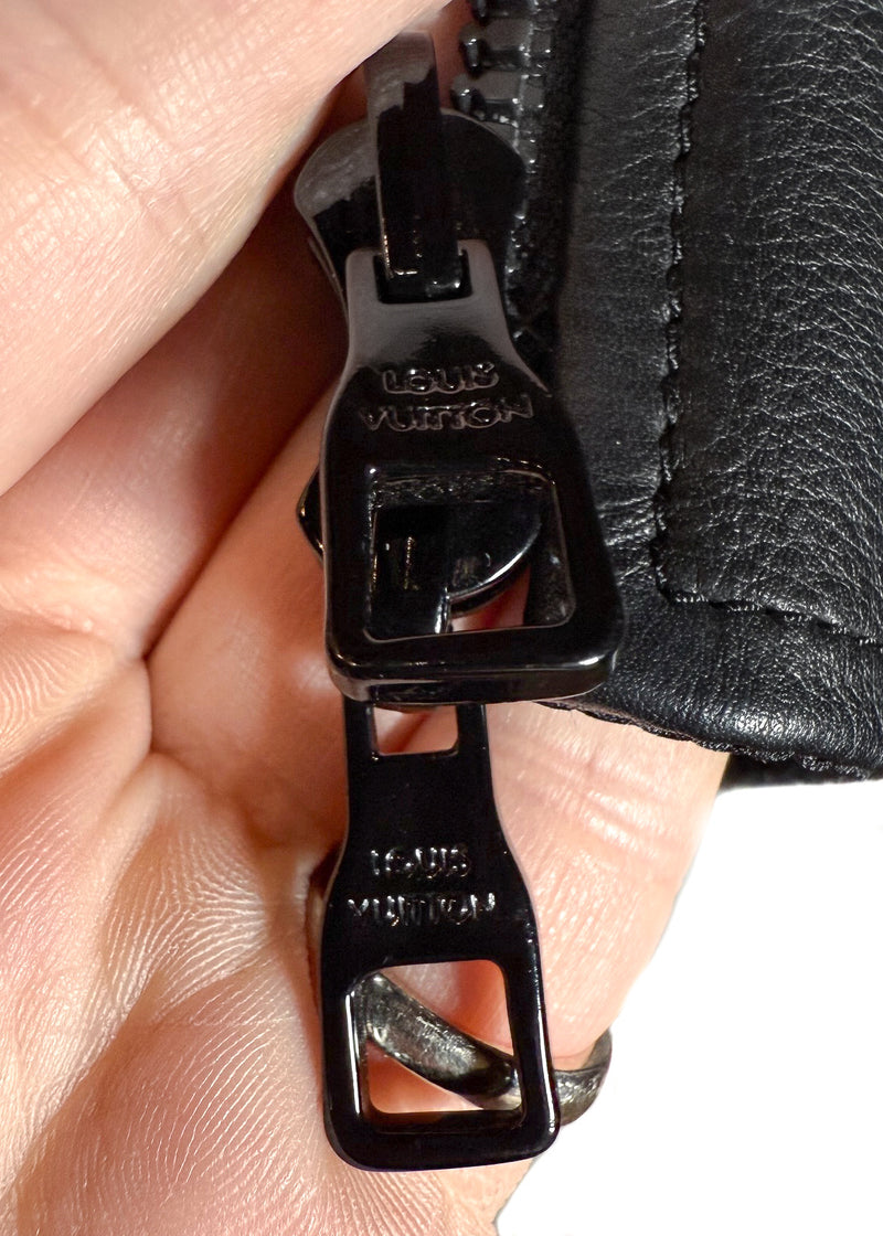 A Louis Vuitton black reversible jacket displayed on a hanger. One side features smooth black leather with ribbed cuffs, collar, and hem, while the other side reveals a black nylon fabric adorned with Louis Vuitton's signature monogram pattern. Close-up shots highlight the premium leather texture, monogram fabric, branded zipper pulls, and the Louis Vuitton logo label. Additional images show the jacket's reversible design, interior details, and stitching.