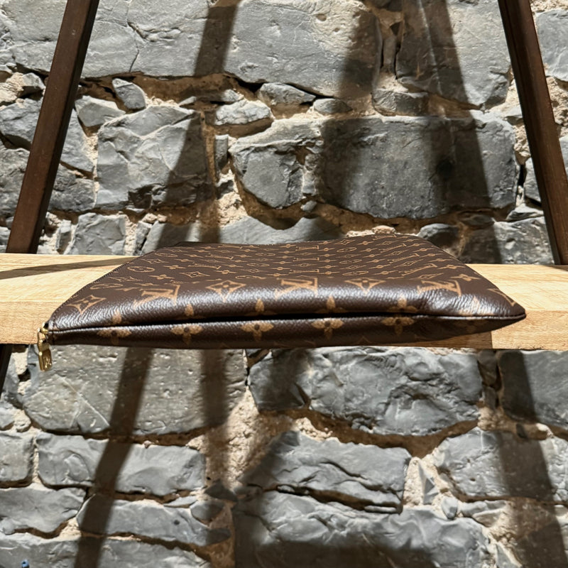 A side view of Louis Vuitton Etui Voyage Brown Monogram GM Pouch
