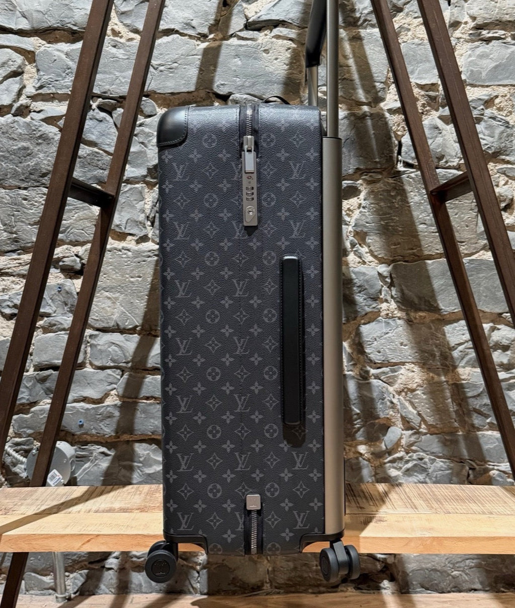 A side view of Louis Vuitton Horizon 70 Monogram Eclipse Luggage