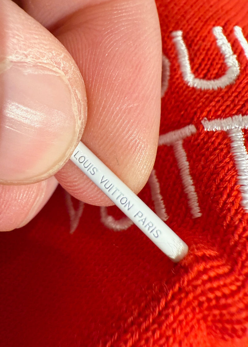 Close-up on Branded pin detail of Louis Vuitton Orange Pin Logo Embroidered Knitted T-shirt