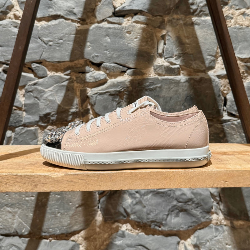 A side view of Miu Miu Nude Pink Patent Crystal Cap Top Sneakers