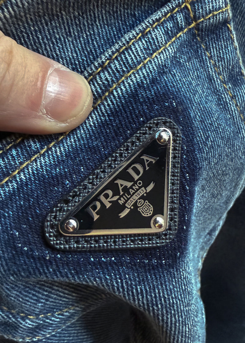 Close-up of black enamel triangle logo plaque on Prada 2021 Washed Blue Triangle Logo Straight Leg Jeans