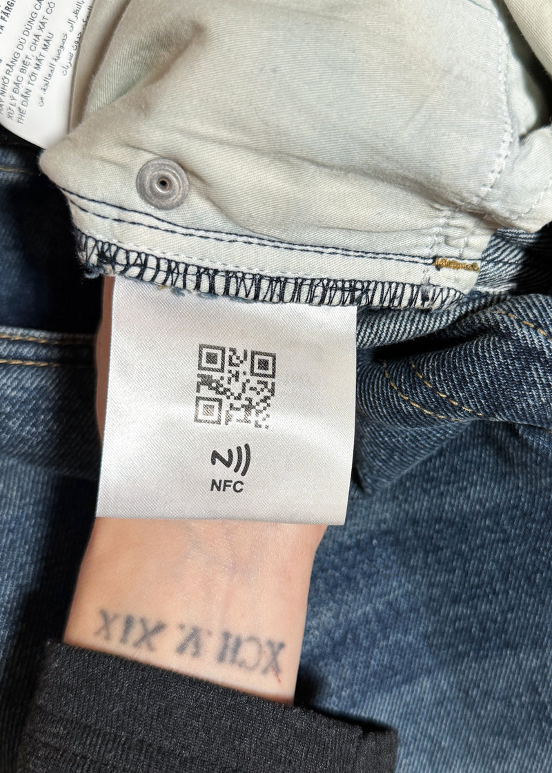 a label featuring a QR code and NFC chip for authentication of Prada 2021 Washed Blue Triangle Logo Straight Leg Jeans