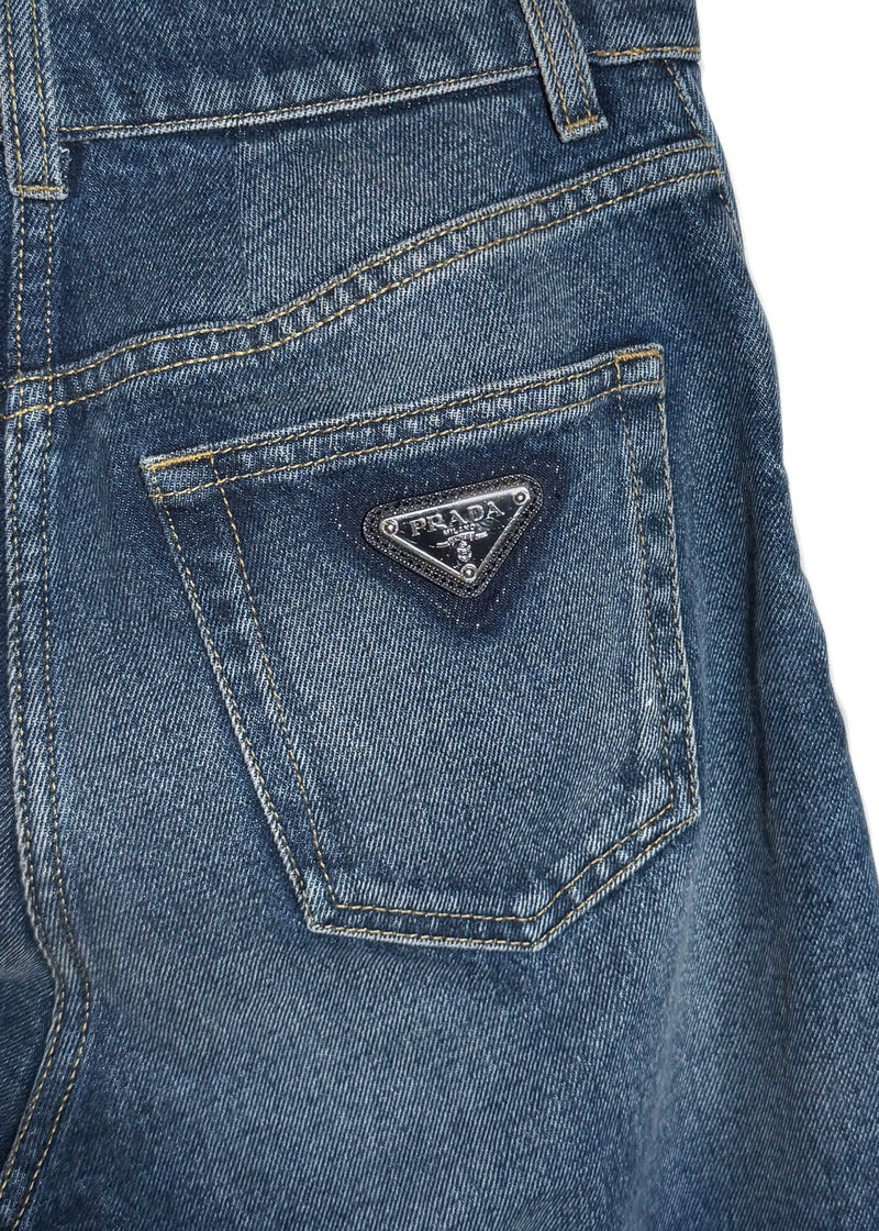 Close-up of back patch pocket featuring a black enamel triangle logo plaque on Prada 2021 Washed Blue Triangle Logo Straight Leg Jeans