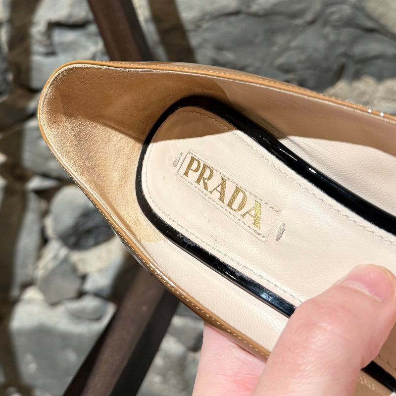 A branded insole of Prada Beige Black Patent Open Toe Pumps