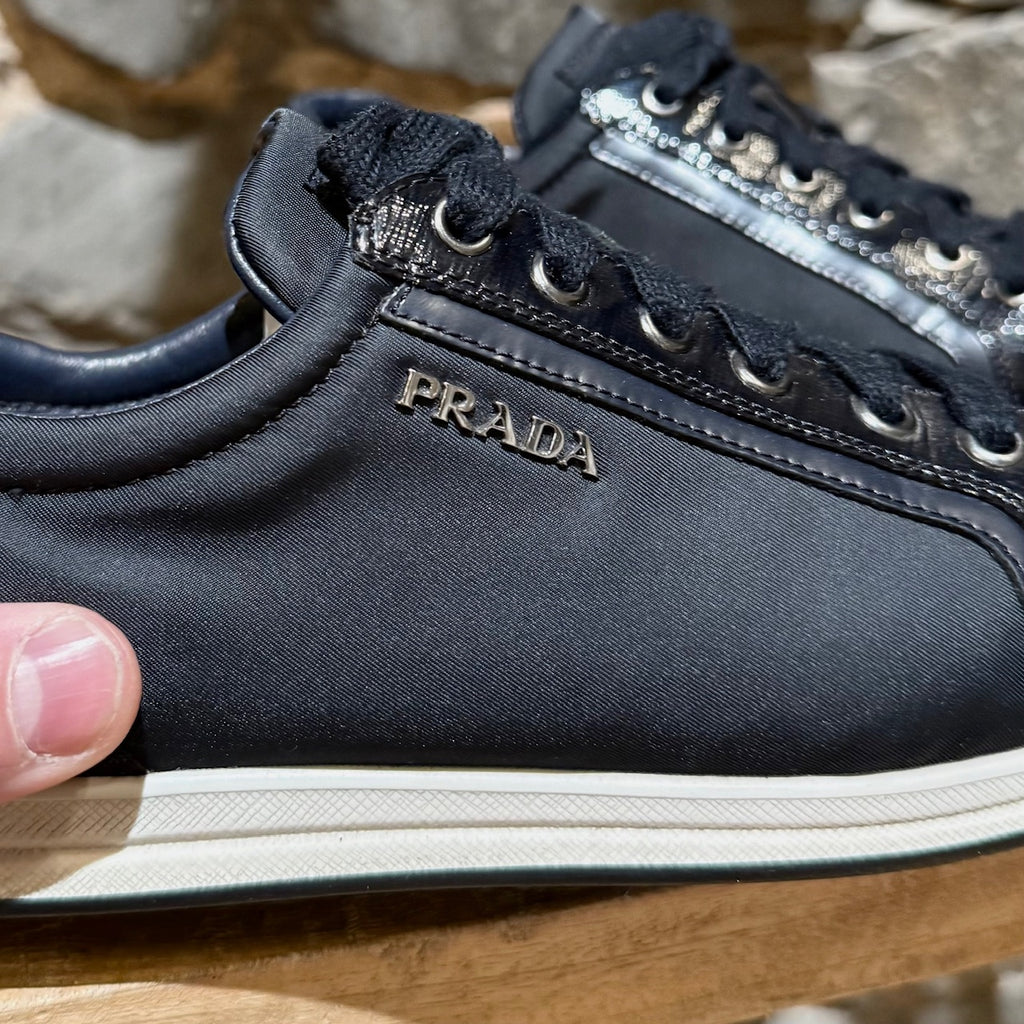 Metallic hardware logo appliqué of Prada Linea Rossa Navy Blue Patent Leather Nylon Low-Top Sneakers