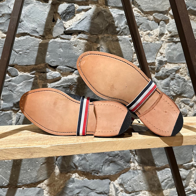 Outsole of Thom Browne Black Pebbled Grosgrain Tricolour Strap Long Wingtip Shoes