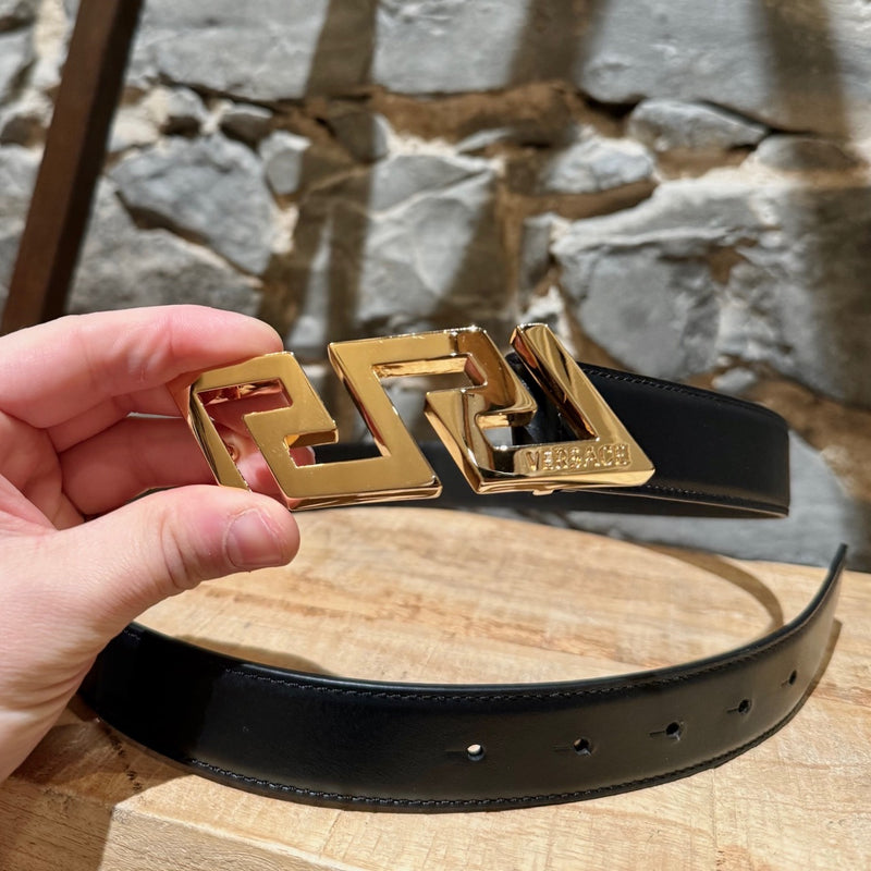 Versace black leather belt featuring a bold gold-tone Greca buckle